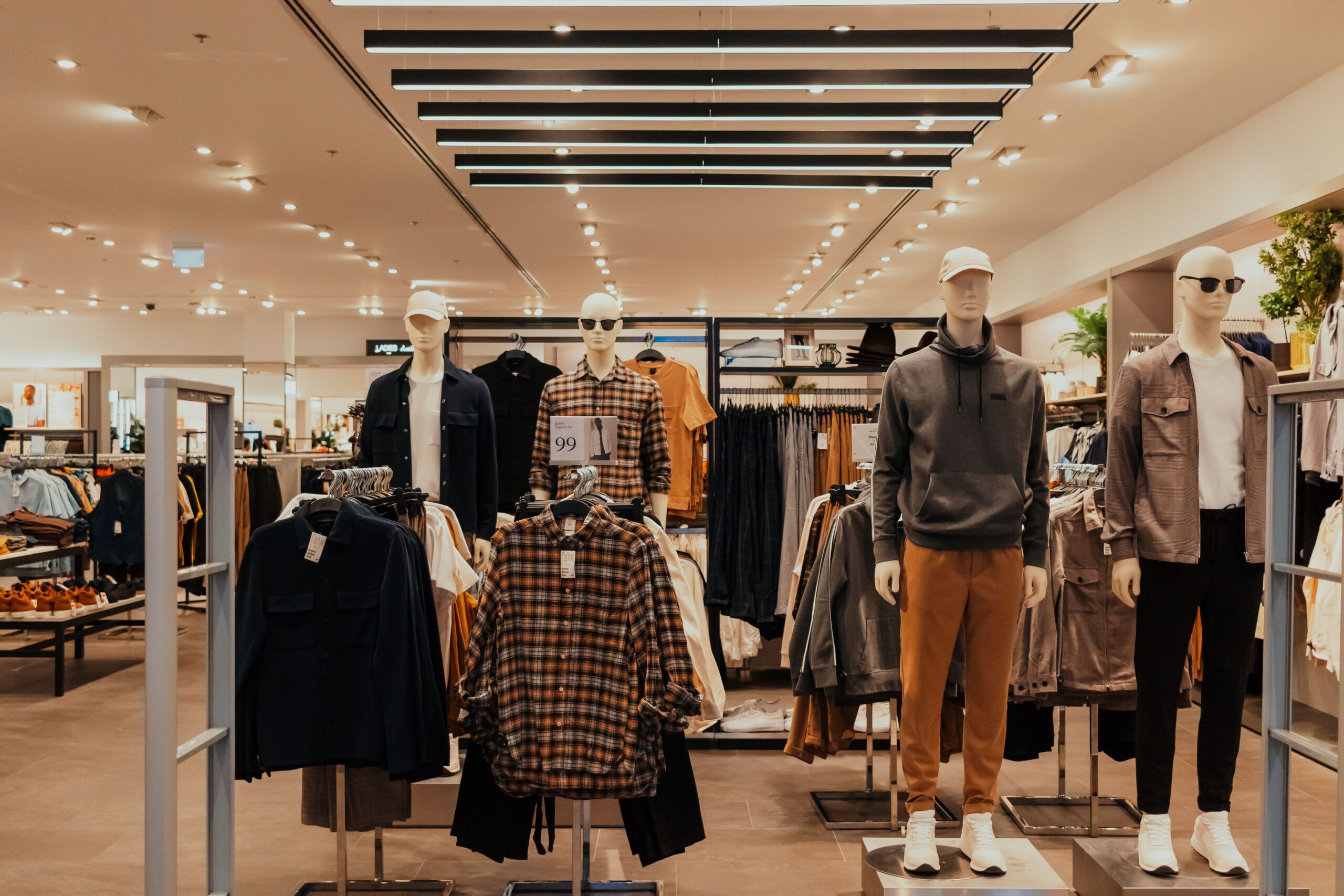 Chic, minimalist boutique clothing store interior with modern apparel displays, showcasing retail marketing and brand development solutions.