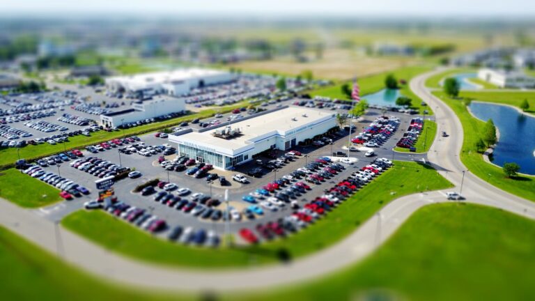 An architectural automotive showroom setting featuring a sleek electric vehicle on display with modern digital displays showing inventory interactive options in soft daylight.